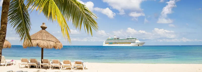 Kreuzfahrtschiff vor einem Strand in der Karibik